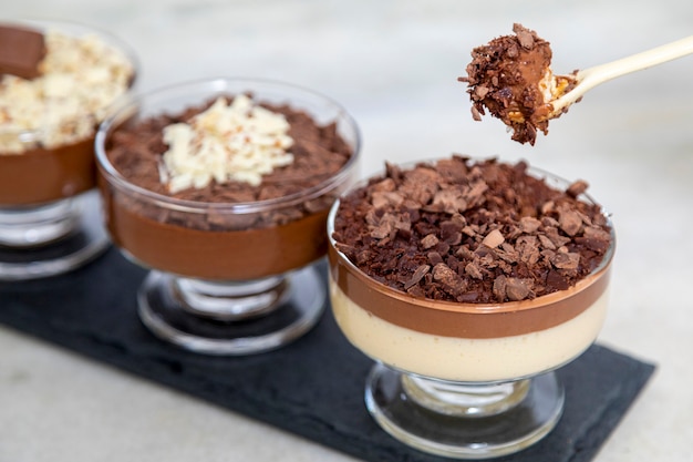 Chocolate mousse on spoon with white chocolate shavings.