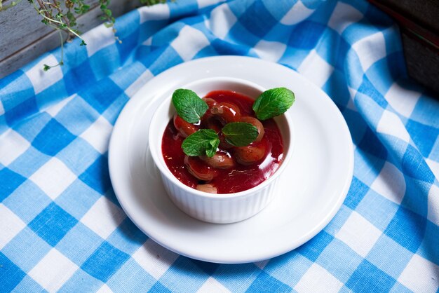 Photo chocolate mousse with berry coulis decorated with mint leaves