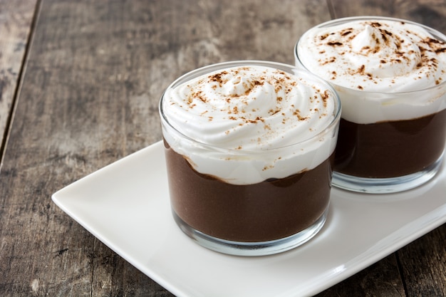 Chocolate mousse with cream on wooden table