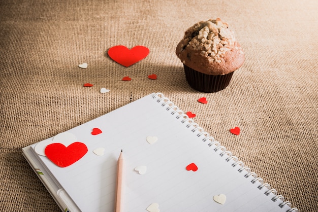 Muffin al cioccolato e cuori su trame di sacco