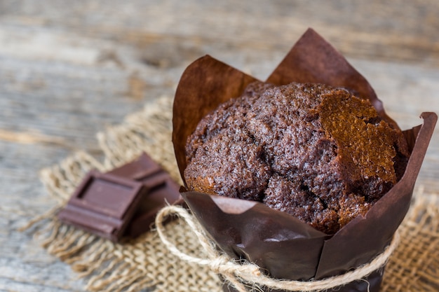 Chocolate muffin on wooden surface.