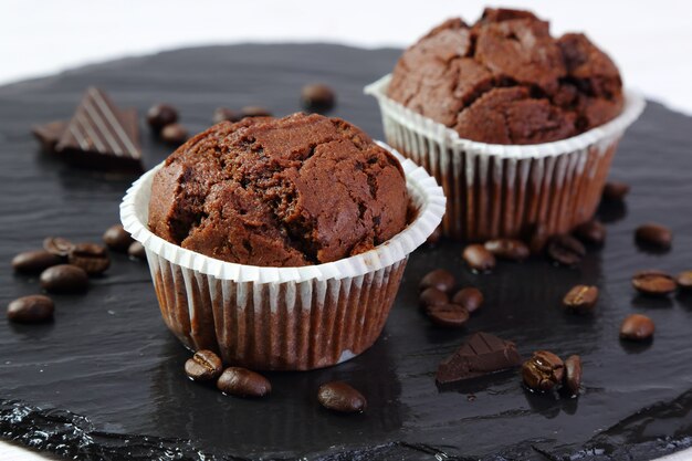 Chocolate muffins on a black tray, selective focus