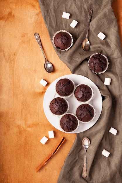 Chocolate muffins on a plate on a wooden table