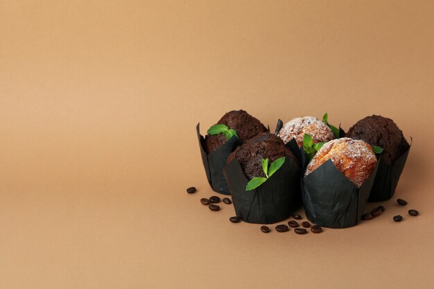 Photo chocolate muffins with coffee seeds on beige background.