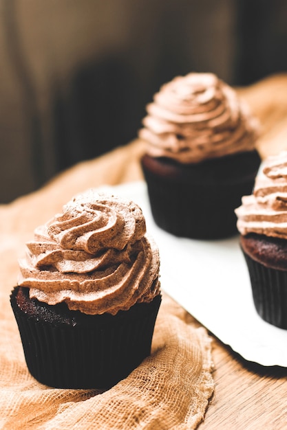 Muffin al cioccolato con crema su un tavolo di legno. muffin fatti in casa. dolce