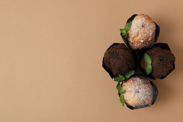 Chocolate muffins with mint on beige background.