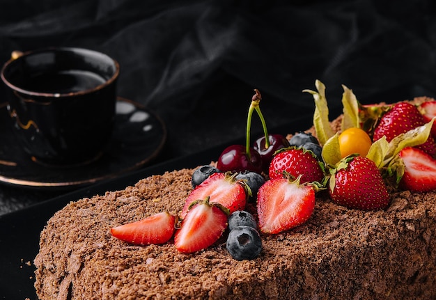 Chocolate Napoleon cake with berries on stone plate