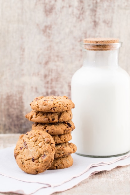 Chocolate oatmeal chip cookies with milk on rustic wooden table.