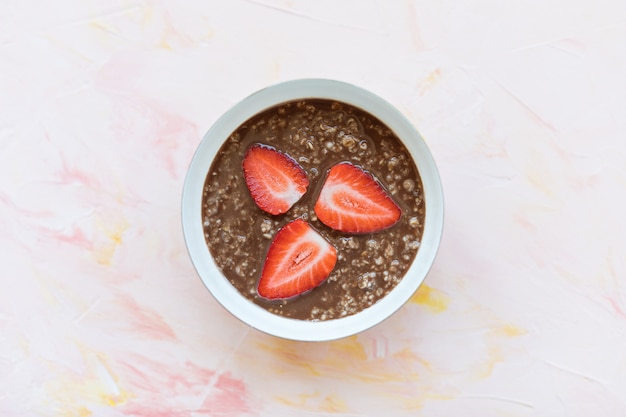 Chocolate oatmeal porridge and strawberry in bowl