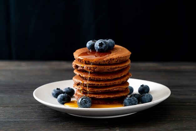 chocolate pancake stack with blueberry and honey on plate