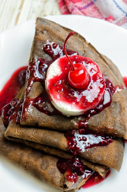 Chocolate pancake with ice cream and raspberry jam