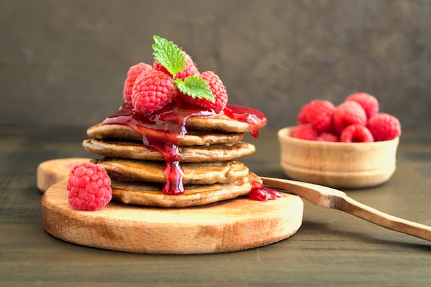 Chocolate pancakes with raspberry on a dark background.