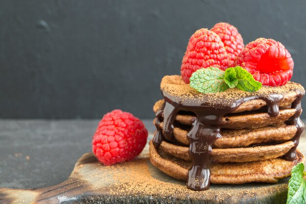 暗い背景にラズベリーとチョコレートのパンケーキ。