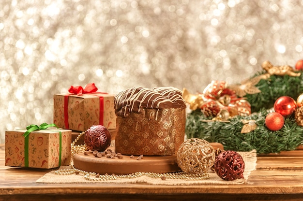 クリスマス飾りと木製のテーブルの上のチョコレートパネットーネ