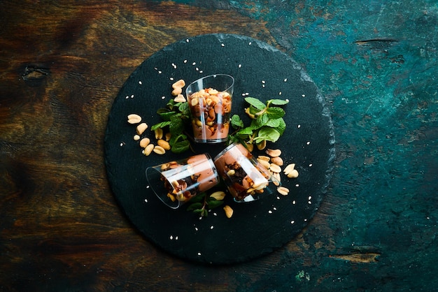 Шоколадный арахисовый десерт в пластиковых стаканчиках Конфетный батончик Вид сверху Деревенский стиль