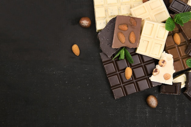 Chocolate pieces with mint leaves on black background