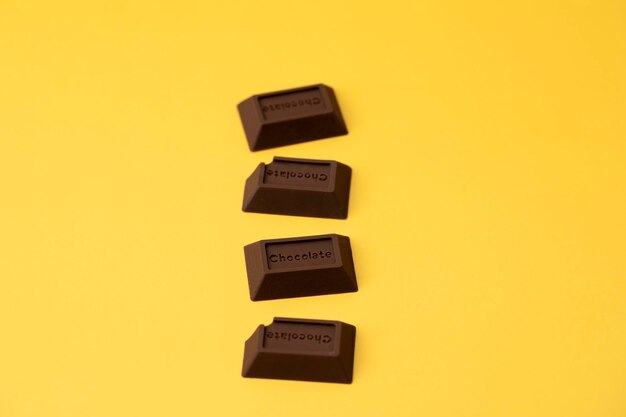 Foto pezzi di cioccolato su sfondo giallo