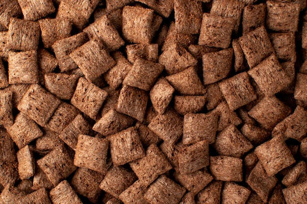 Chocolate pillows background texture. Brown choco cereal pads.