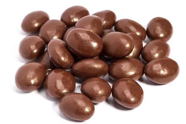 Foto pillole di cioccolato in mucchio isolato su sfondo bianco