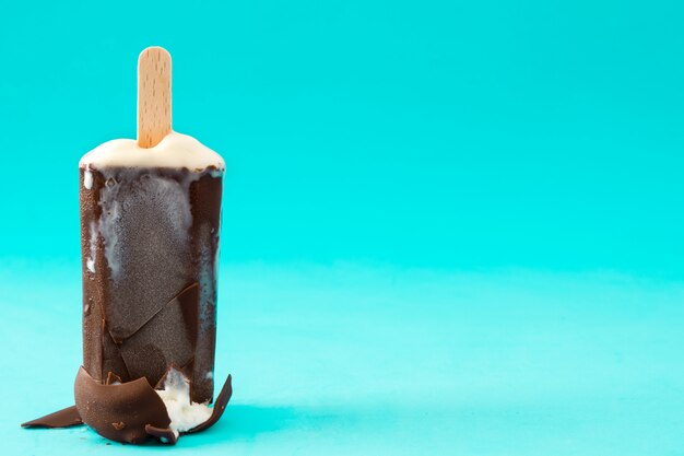 Foto ghiacciolo al cioccolato sul tavolo blu