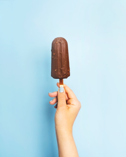 Photo chocolate popsicle on stick in hand