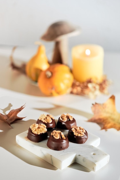 Chocolate pralines with walnut nuts on marble cutting board Closeup on candy