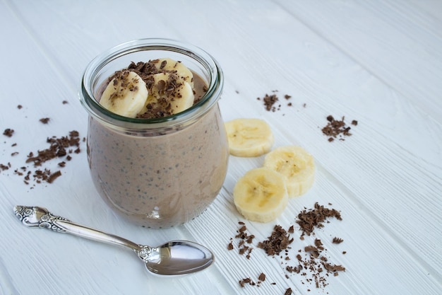 Chocolate pudding with chia and banana on the white wooden background