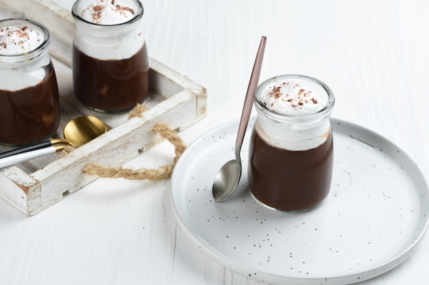 chocolate pudding with whipped cream and chocolate as topping in portion glasses