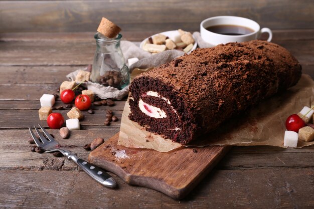 Chocolate roll with cream and berries on table close up