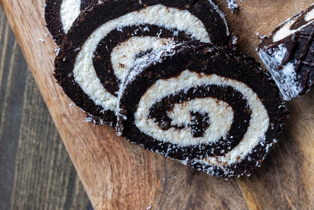 Chocolate roll with a creamy curd layer in coconut chips