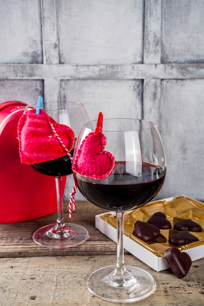 Chocolate, roses, wine glasses and heart box on wooden table