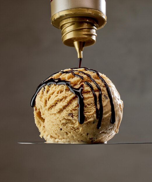 Chocolate sauce pouring on ice cream