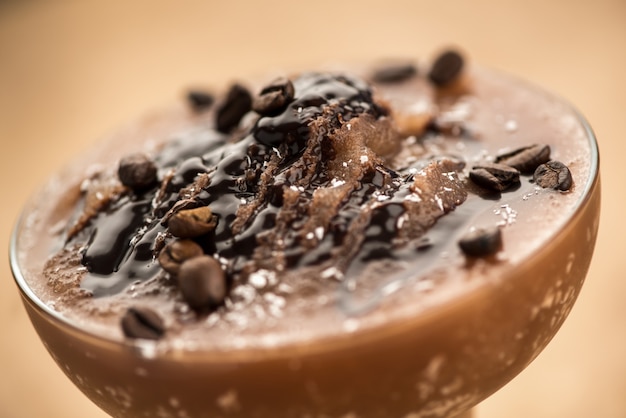 Chocolate smoothie on light brown background, close up