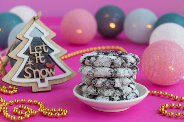 Chocolate snowy cookies on a pink background