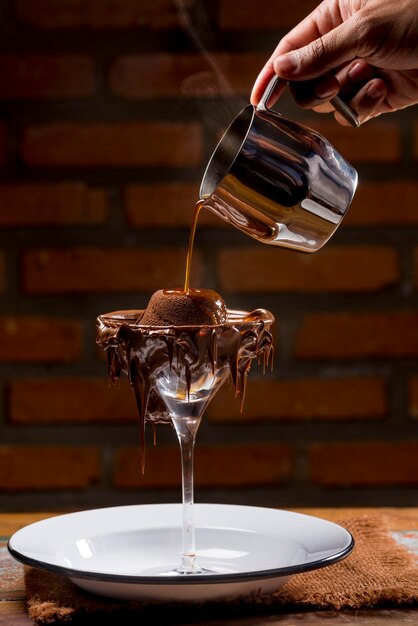 Chocolate Souffle being poured into a glass with petit gateau