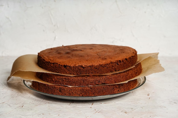 Strati di torta senza farina in spugna di cioccolato con sfondo chiaro di carta da forno torta brownie