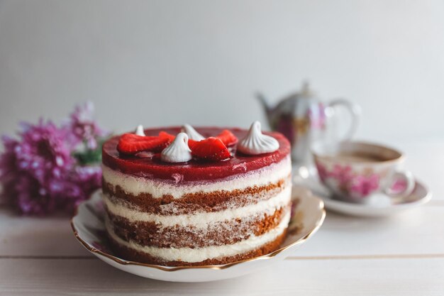 木のテーブルに新鮮な果物で飾られたチョコレートストロベリーヨーグルトケーキバレンタインや誕生日パーティーのためのおいしくて甘いピンクのストロベリーケーキ自家製ベーカリーのコンセプト