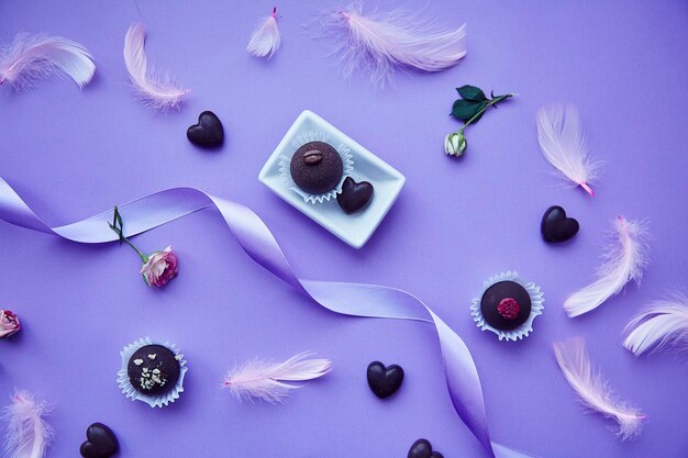 Chocolate sweets and hearts Trendy pink feathers Delicate purple very peri color pattern Birthday invitation greetings and wishing concept