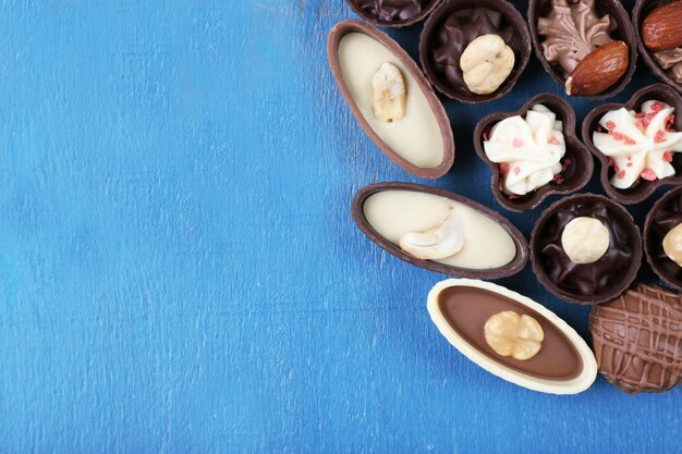 Шоколадные конфеты на старом синем деревянном фоне, вид сверху