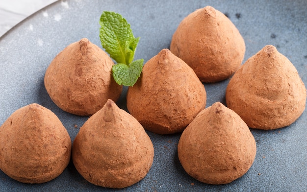 Chocolate truffle on blue ceramic plate. 