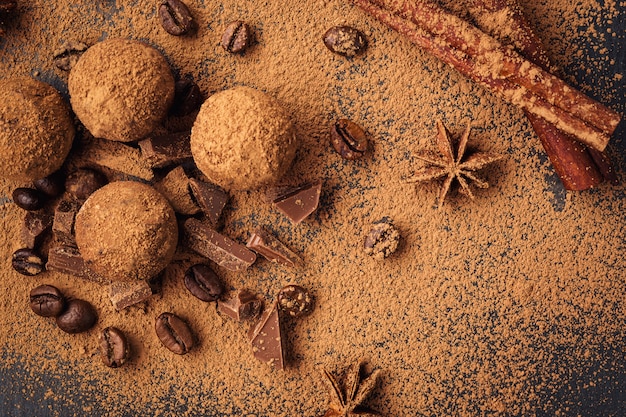 Tartufo al cioccolato, caramelle al cioccolato al tartufo con cacao in polvere. palline di energia fresca fatta in casa con cioccolato. tartufi gommosi assortiti da cioccolataio. pezzi di cioccolato e chicchi di caffè