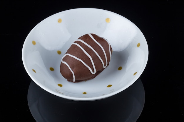 Chocolate truffle with strawberry filling isolated on black