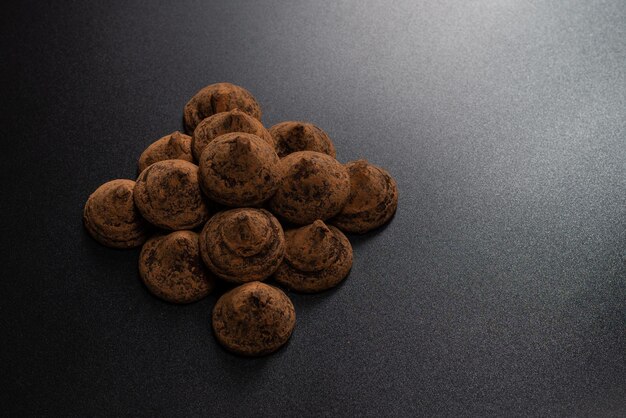 Chocolate truffles on a black background. Chocolate candies.