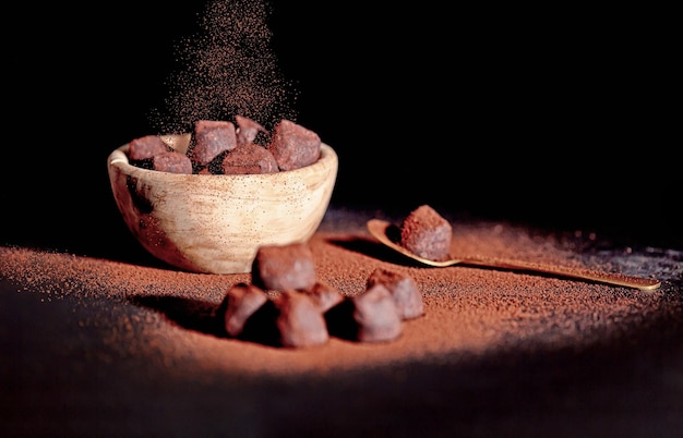 Chocolate truffles covered with cocoa powder in a wooden cup