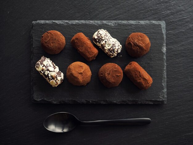 Chocolate truffles on dark stone table
