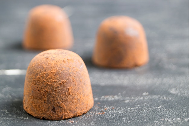 Chocolate truffles on a grey background.