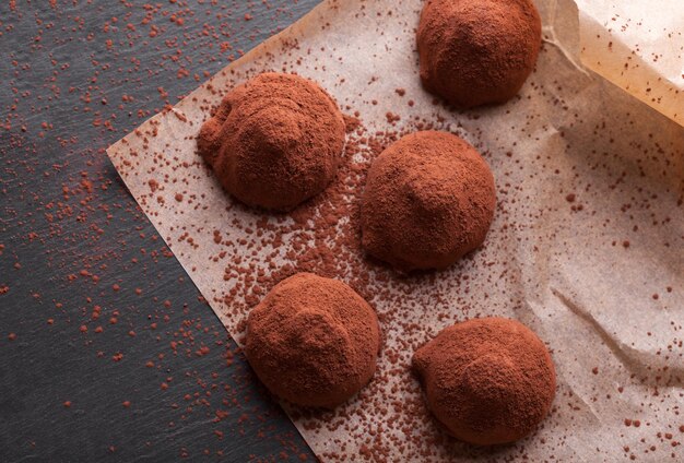 Chocolate truffles with sweet cream inside on the wooden background