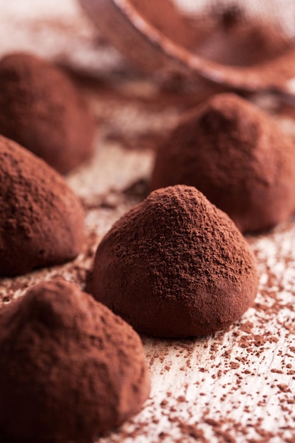 Chocolate truffles with sweet cream inside on the wooden background