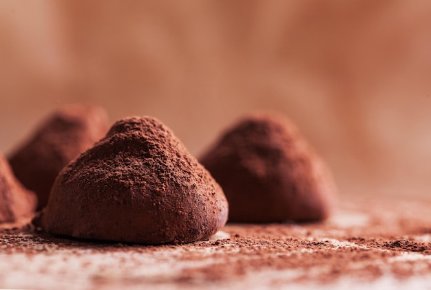 Chocolate truffles with sweet cream inside on the wooden background