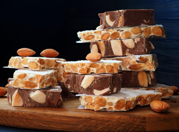 Chocolate turron with almonds hard alicantian turron on a vintage wooden board